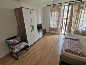 - une chambre avec un lit, une chaise et une télévision dans l'établissement Guesthouse Zimovski, à Pechtani