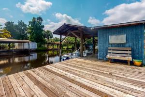 a wooden dock with a bench next to a building at Sunshine House in Astor