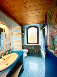a bathroom with a sink and a toilet and a window at Collina Blu in Bolsena