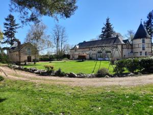 a large house with a large yard in front of it at La Tour de rêves in Beaumont-la-Ronce