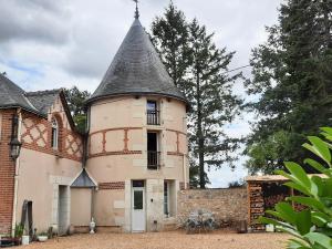 un antiguo edificio con una torre encima en La Tour de rêves en Beaumont-la-Ronce