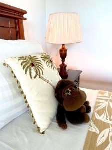 un osito de peluche sentado en una cama junto a una almohada en Spice of Ceylon en Chilaw