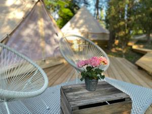 a table with two chairs and a vase with flowers on it at tent romantica a b&b in a luxury glamping style in Mariefred