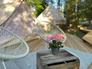 una mesa con dos sillas y un jarrón con flores. en tent romantica a b&b in a luxury glamping style, en Mariefred