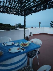 einem blauen Tisch mit Platten aus Essen auf dem Dach in der Unterkunft Bed and Breakfast Villa Angelina in Lipari