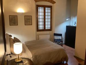 um quarto com uma cama com um candeeiro e uma janela em Central and quiet apartment em Florença
