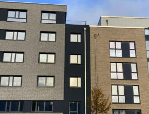 a tall building next to two shorter buildings at Arbio I Duxen Apartments Hagenbeck Zoo in Hamburg