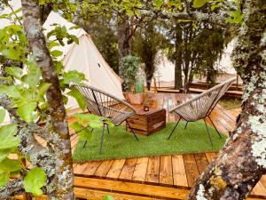 a wooden deck with two chairs and a tent at koh tenta a b&b in a luxury glamping style in Mariefred