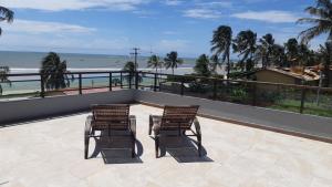 two chairs sitting on a balcony looking at the beach at Flêbeach in Flecheiras