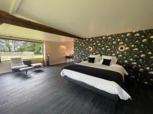 a bedroom with a large bed with flowers on the wall at Villa Fleurie in Grandchain