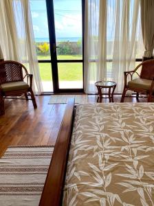 1 dormitorio con cama, sillas y ventana grande en Spice of Ceylon en Chilaw