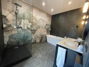 ein Bad mit einer Dusche und einem Waschbecken in der Unterkunft Villa Fleurie 