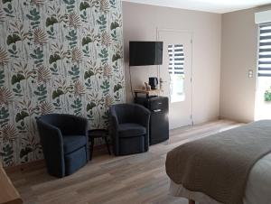 a bedroom with two chairs and a bed and a kitchen at Chambres et Tables d'hotes " O Doux Matins " aux portes de Chinon in Rivière