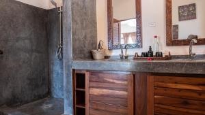 La salle de bains est pourvue d'un lavabo et d'une douche. dans l'établissement Raha Lodge Zanzibar Boutique Hotel, à Jambiani