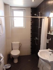 a bathroom with a toilet and a sink and a window at Belogradchik View Apartment in Belogradchik