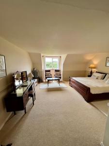 ein großes Schlafzimmer mit einem Bett und einem Schreibtisch in der Unterkunft Faul House in Clifden