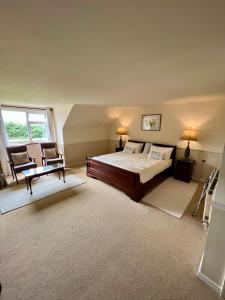 a bedroom with a bed and two chairs in it at Faul House in Clifden