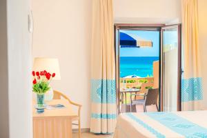 a hotel room with a bed and a table with a vase of flowers at Hotel Dei Pini in Alghero