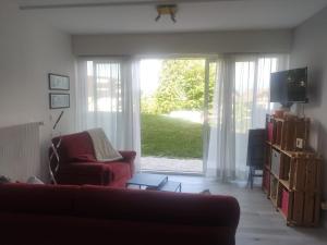 sala de estar con sofá y puerta corredera de cristal en gîte Amolinnes F2 5mn douane croix de rozon 20mn Genève en Collonges-sous-Salève