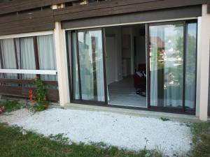 um alpendre coberto de uma casa com portas de vidro deslizantes em gîte Amolinnes F2 5mn douane croix de rozon 20mn Genève em Collonges-sous-Salève