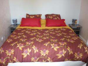 a bedroom with a bed with red pillows at gîte Amolinnes F2 5mn douane croix de rozon 20mn Genève in Collonges-sous-Salève