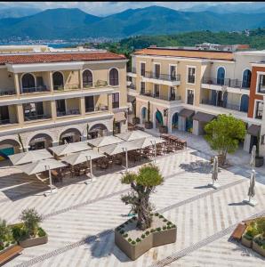a courtyard with tables and umbrellas in a building at Lustica Bay Centrale Sparcle in Tivat