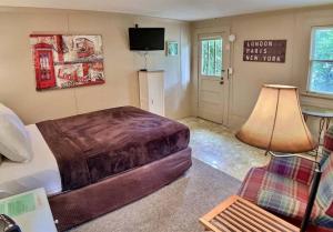 1 dormitorio con cama, lámpara y TV en The London Flat #4/ Oak Crest, en Eureka Springs