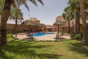 un complejo con piscina y palmeras en Boudl Al Fayhaa, en Riad