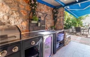an outdoor kitchen with a stone wall at 3 Bedroom Amazing Home In Kraljevica in Kraljevica +40 photos