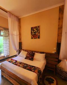 a bedroom with two beds and a painting on the wall at Haradali's Home in Arusha