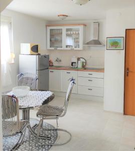 a kitchen with a table and chairs and a refrigerator at Apartment Marina in Marina +7 photos