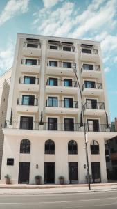 a tall white building with windows and balconies at Kondo Hotel Allure in Budva
