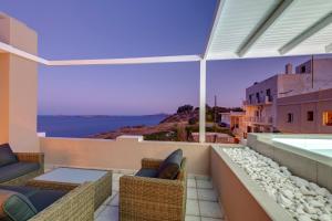a balcony with chairs and a view of the ocean at Aegean Glory Suites in Ermoupoli
