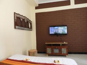 a bedroom with a tv on a brick wall at Jogoo rooms in Dar es Salaam