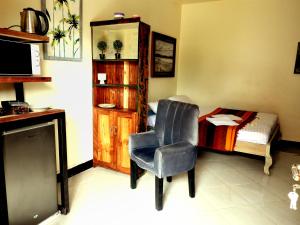 a room with a chair and a bedroom with a bed at Jogoo rooms in Dar es Salaam