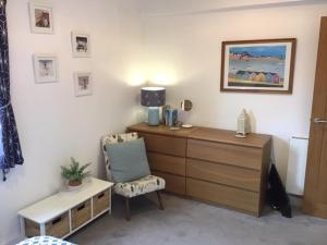 a bedroom with a desk and a chair and a dresser at Stunning penthouse apartment in Teignmouth in Teignmouth