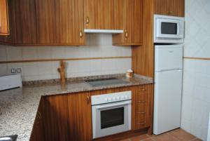 a kitchen with wooden cabinets and a white stove top oven at El Mirador de Riópar Viejo in Riópar