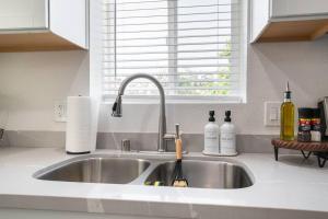 a kitchen sink with two bottles of wine on it at Urban Oasis: San Diego Bungalow Escape in San Diego