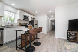 uma cozinha com armários brancos e uma mesa com uma cadeira em Urban Oasis: San Diego Bungalow Escape em San Diego