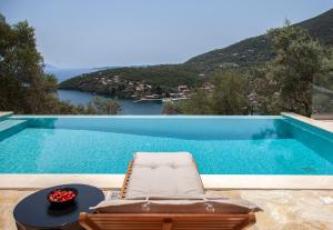 a chair sitting next to a swimming pool at Villa Dara and Todd in Sivota