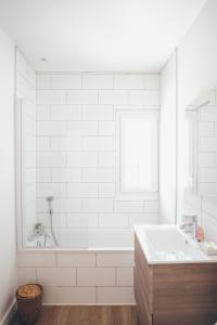 a white bathroom with a tub and a sink at Villa de l'Etang Blanc in Seignosse