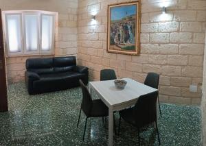 - un salon avec un canapé, une table et des chaises dans l'établissement Il colore del Salento, à Carpignano Salentino