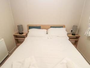 a bedroom with a white bed with two night stands at Moon Stone in Morpeth