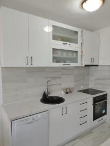a white kitchen with white cabinets and a sink at Royal Apartment Bar in Bar +22 photos