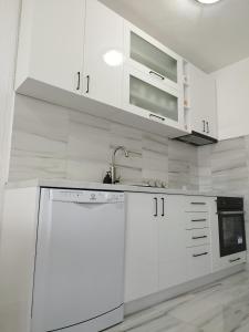 a white kitchen with a sink and a dishwasher at Royal Apartment Bar in Bar