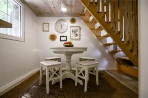 a table and stools in a room with a staircase at REDIBO Erdei Vendégház in Kismaros