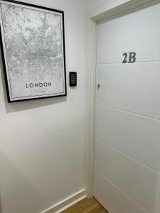 une porte menant à une chambre avec une photo sur le mur dans l'établissement New 2B Soho Studios by Indigo Flats Sleeps 4, à Londres