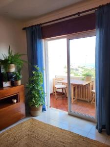 a living room with a sliding glass door to a patio at Studio Apartment with Sea View & Fibre Internet in Albufeira