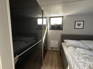 Habitación pequeña con 2 camas y espejo. en Hausboot La Mare Seeblick, en Weyhe
