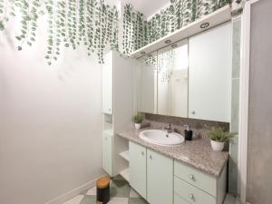 un bagno con lavandino e specchio di Jungle Urbain- Sauna - Ciné - Hamac - Hyper centre ad Amiens Altre 32 foto